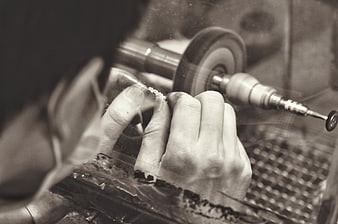 Close-up of hands polishing jewelry in workshop
