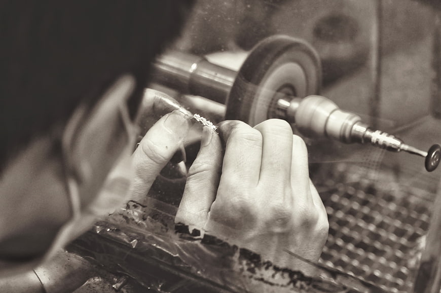 Close-up of hands polishing jewelry in workshop