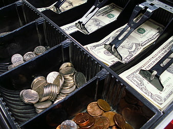Close-up of cash register drawer with coins and bills