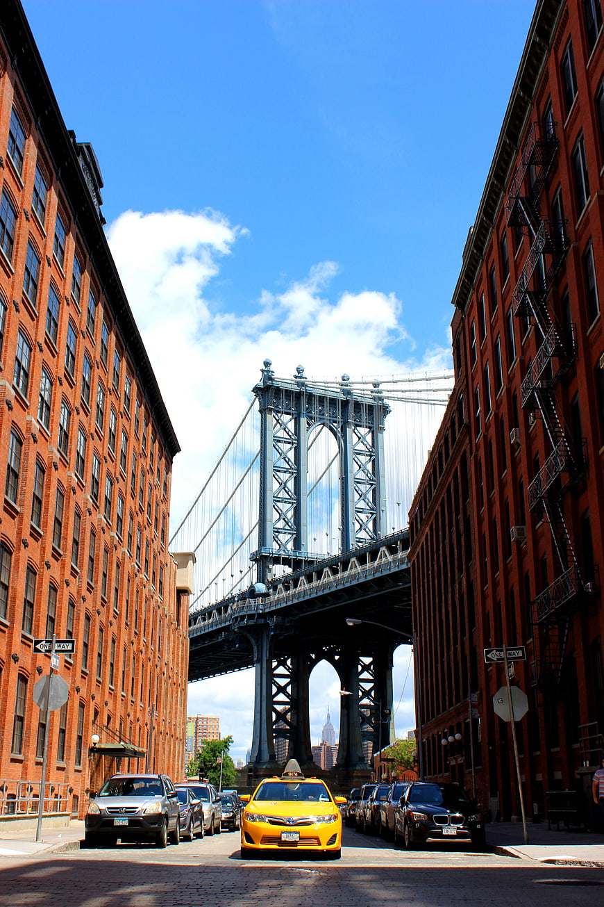 Yellow Taxi Cab Driving Under Manhattan Bridge in DUMBO Brooklyn