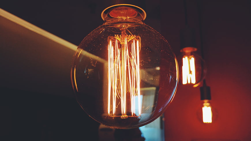 Vintage Edison light bulb glowing in a dim interior