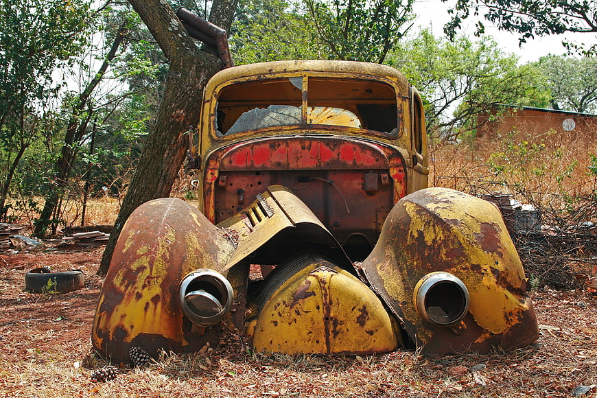 Rusty Abandoned Vintage Car Wreck in Overgrown Forest