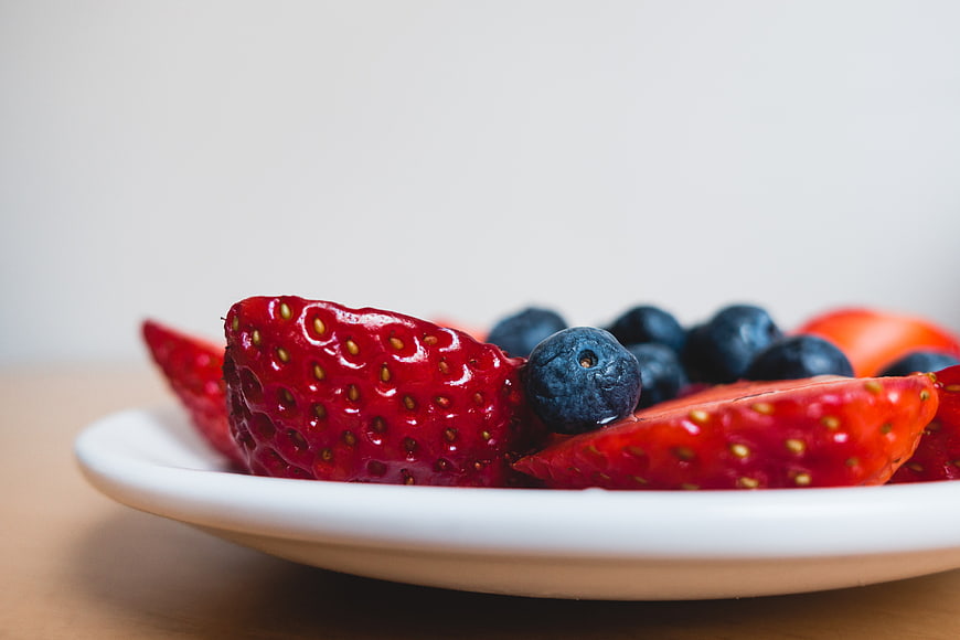 Close-up of fresh strawberries and blueberries on a white plate