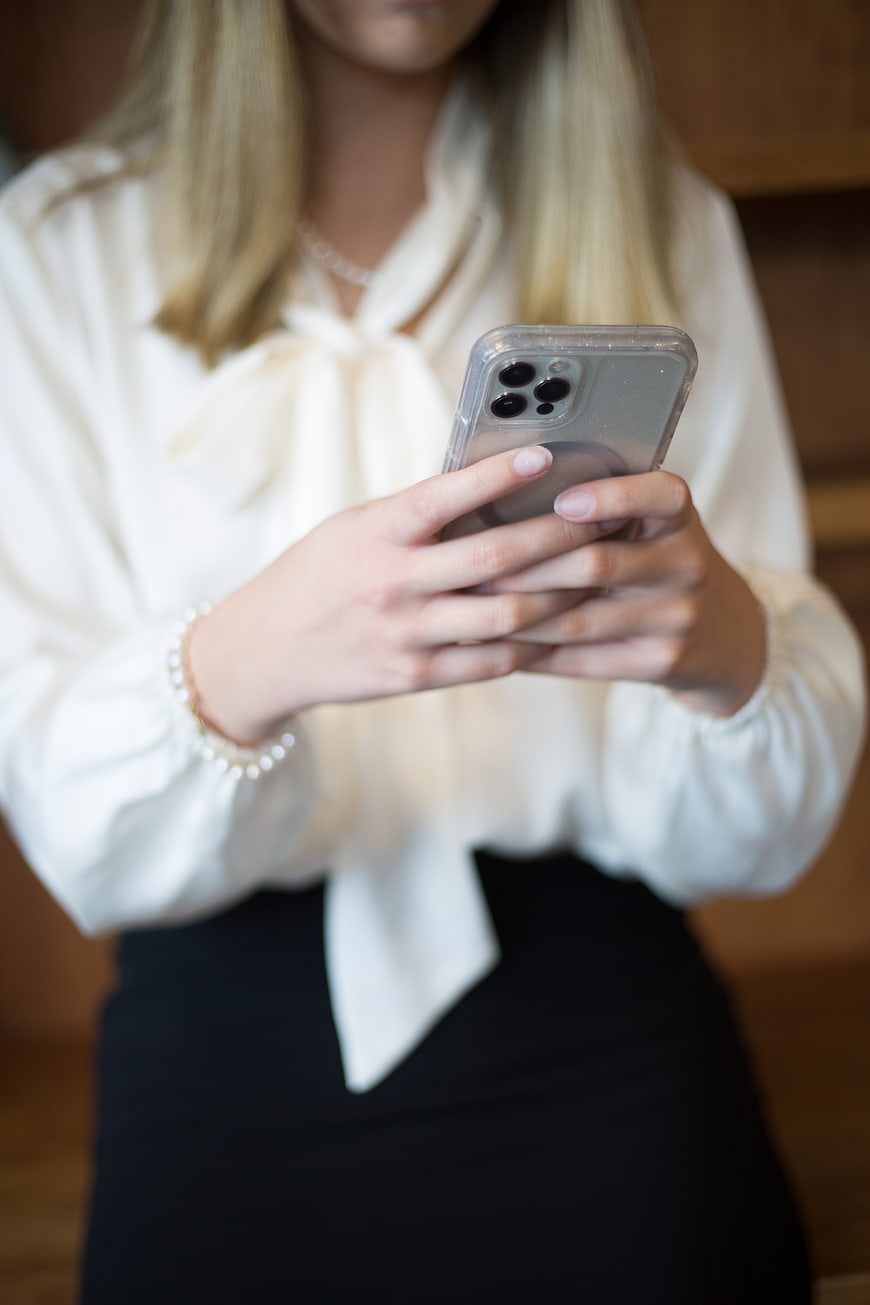 Woman in white blouse using smartphone