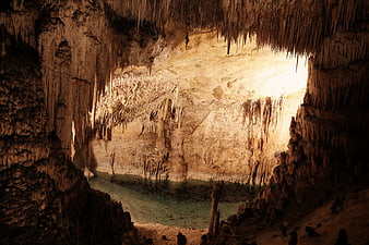 Underground cave with stalactites and turquoise river