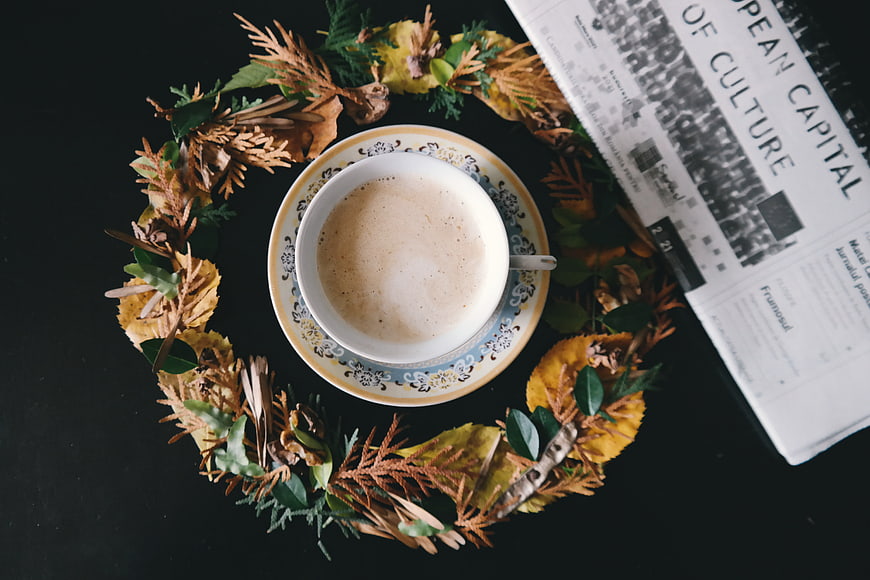 Top view of coffee cup with autumn wreath and magazine