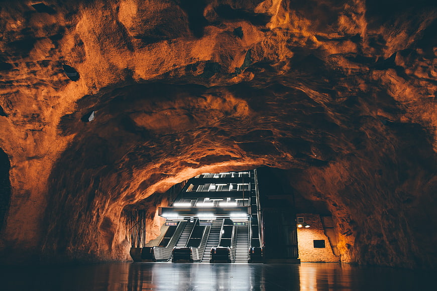 Modern Escalator Entrance in Illuminated Cave Tunnel