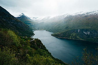 Misty Norwegian Fjord with Snow-Capped Mountains and Winding Road