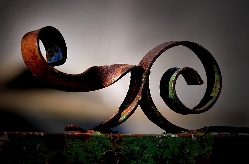 Close-up of Rusted Iron Scrollwork on Green Metal
