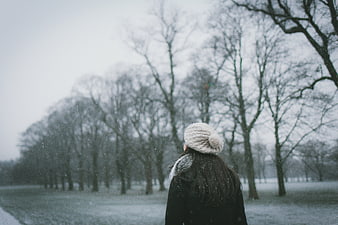 Woman in Beanie Looking at Snowy Winter Park