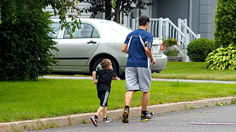Father and son running together on a suburban street