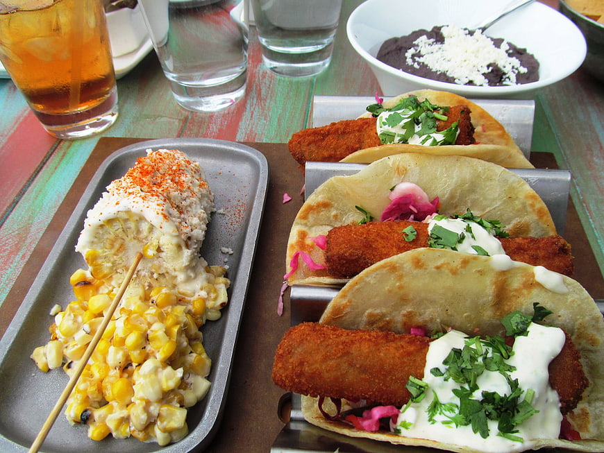 Mexican Food Spread With Tacos And Elote On Rustic Table