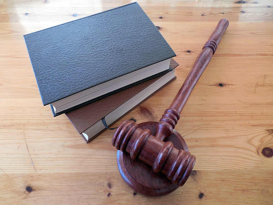 Wooden gavel and law books on a wooden table
