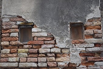 Weathered Brick Wall with Peeling Plaster and Old Windows
