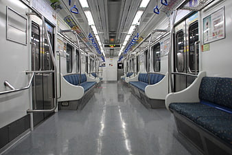 Empty subway car interior with blue seats and metal poles