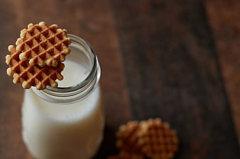 Waffle cookies on milk bottle with rustic wooden background