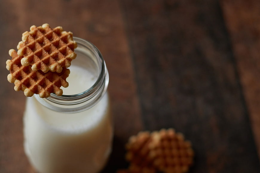 Waffle cookies on milk bottle with rustic wooden background