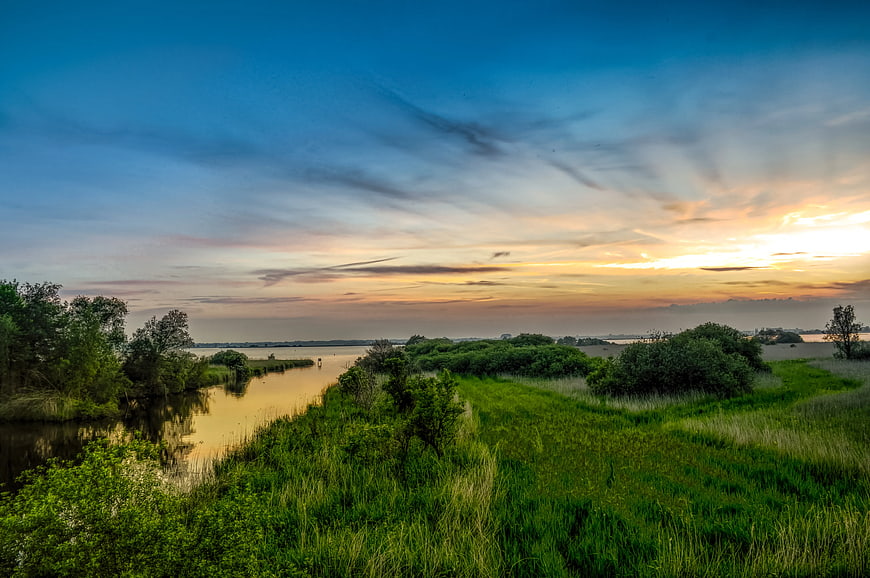 Serene River Landscape at Sunset with Green Banks