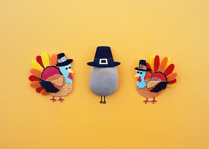 Cute felt turkey and pilgrim rock crafts on yellow background