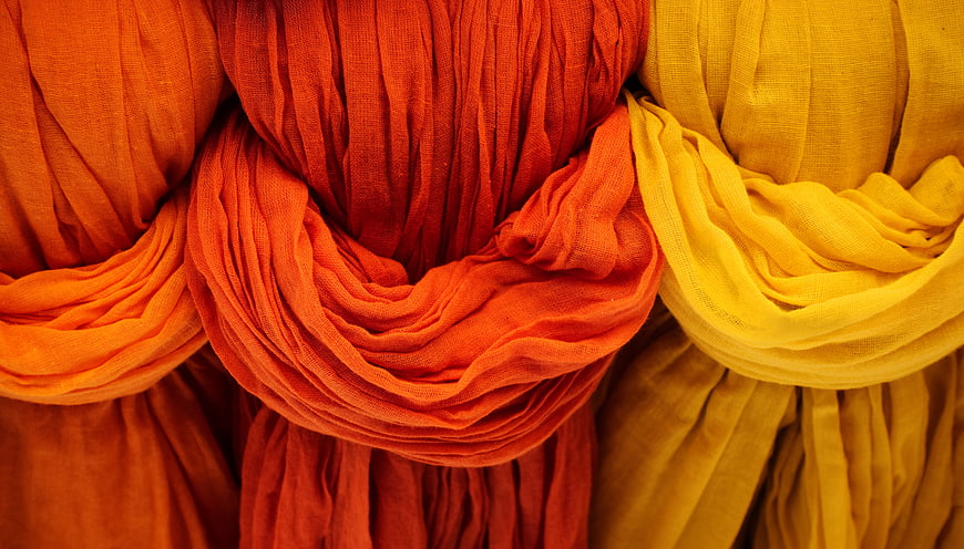 Vibrant Orange and Yellow Draped Fabric Texture Close Up