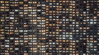Night view of high-rise apartment building facade with lit windows