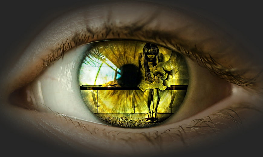 Conceptual photomontage of a woman in distress reflected in a human eye