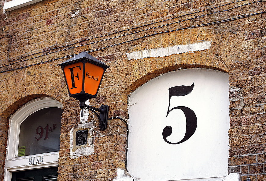 Orange Lantern and Number 5 on Brick Wall