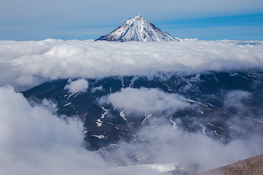 Majestic Snow-Capped Mountain Peak Rising Above Sea of Clouds