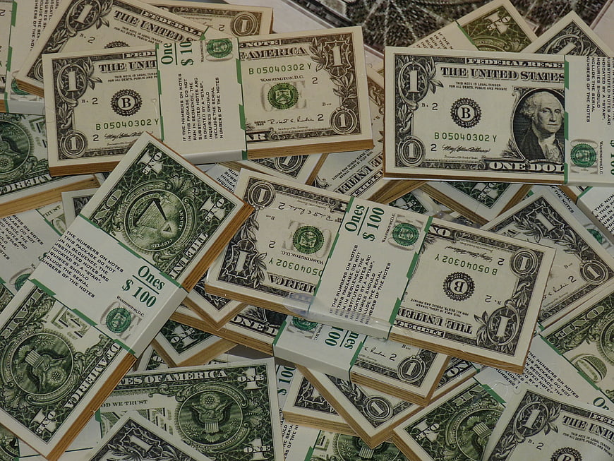 Stacks of One Dollar Bills Scattered on Surface