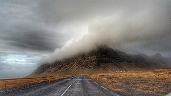 Dramatic Mountain Road with Fog and Overcast Sky