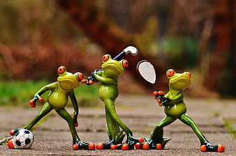 Cute ceramic frog figurines playing sports on a garden path