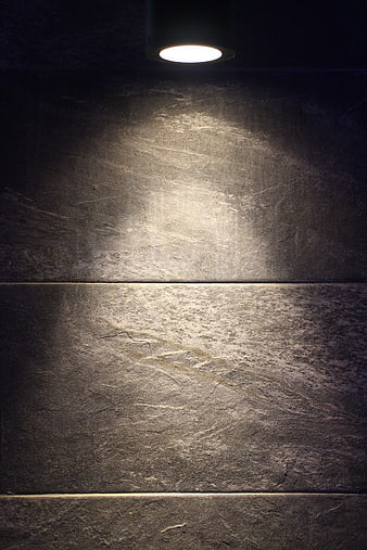 Dark Textured Stone Wall Illuminated By Single Ceiling Spotlight