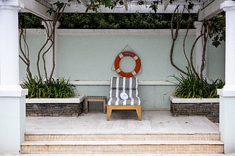 Symmetrical Poolside Lounge with Striped Chair and Lifebuoy