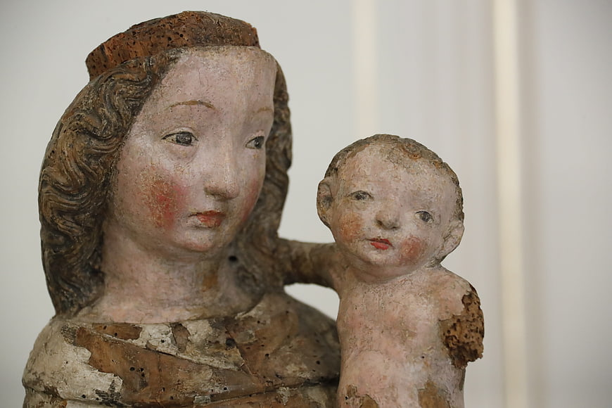 Ancient wooden sculpture of Madonna and Child with weathered paint