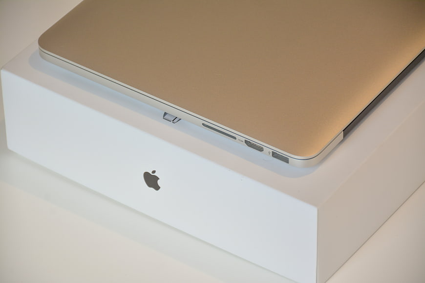 Gold MacBook Pro on White Apple Box