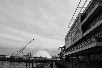 Black and white harbor scene with modern architecture and crane