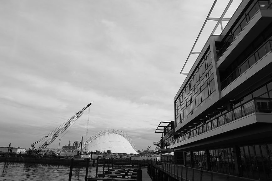 Black and white harbor scene with modern architecture and crane