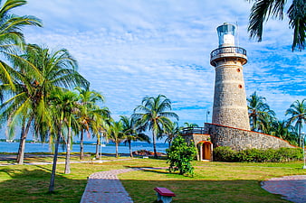 Tropical Lighthouse with Palm Trees and Blue Sky