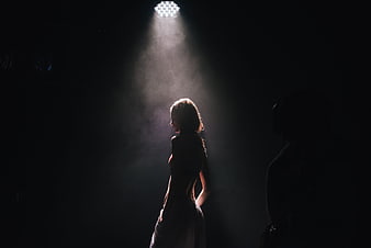 Woman Silhouette in Dramatic Stage Spotlight