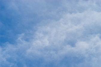 Soft White Clouds Against Blue Sky Background