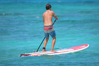Man Stand Up Paddleboarding on Turquoise Ocean Water