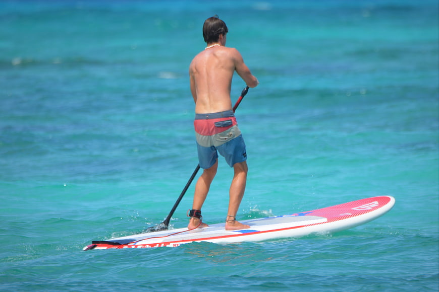 Man Stand Up Paddleboarding on Turquoise Ocean Water