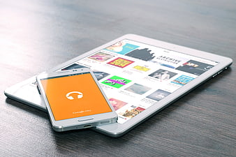Smartphone and Tablet on Wooden Desk with Music App