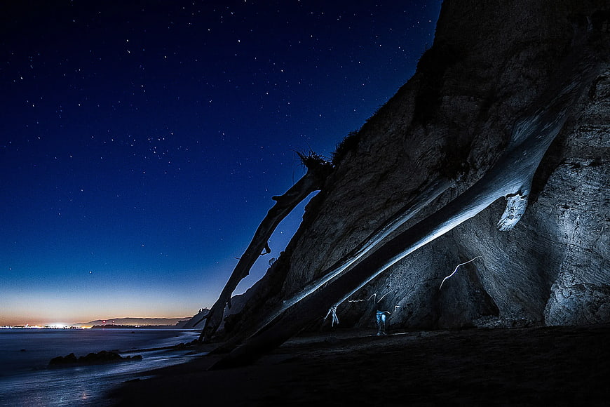 Night Photography of Beach Cave with Starry Sky