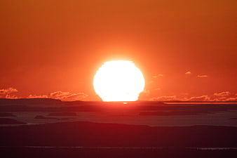 Vibrant Orange Sunset Over Silhouetted Islands and Ocean