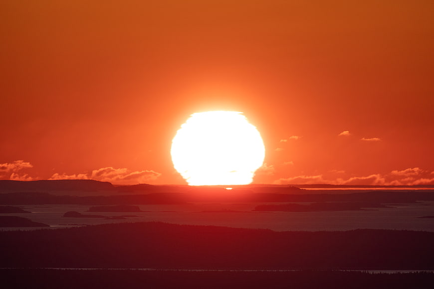 Vibrant Orange Sunset Over Silhouetted Islands and Ocean