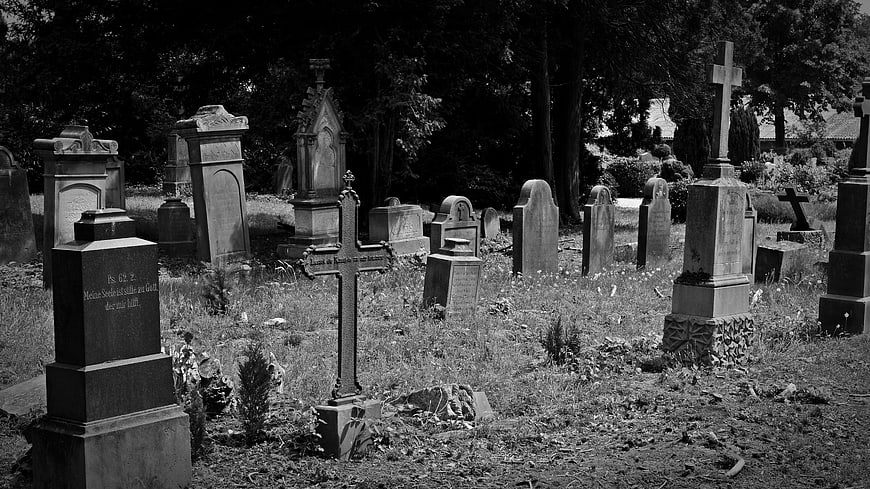 Black and white photo of old abandoned cemetery with crosses