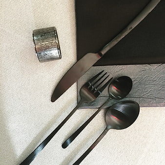 Black matte cutlery set on textured tablecloth