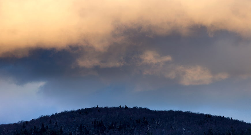 Dramatic Sunset Storm Clouds Over Silhouetted Mountain Ridge