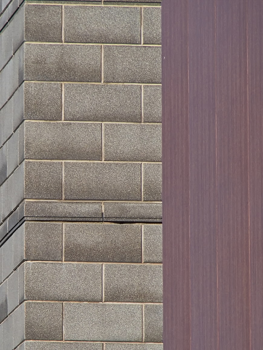 Modern building facade with gray tiles and purple panel